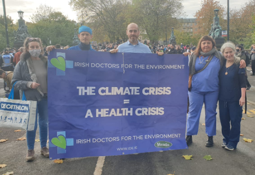 Five doctors posing with banner at COP26 protests in Glasgow